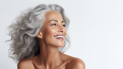 Black adult woman touch face with smooth healthy skin. Beautiful aging mature woman with long gray hair and happy shy smiling. Beauty and cosmetics skincare advertising concept, white background - obrazy, fototapety, plakaty