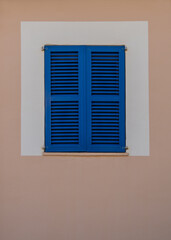 Window with blue, wooden shutters, dark blinds to prevent light from entering