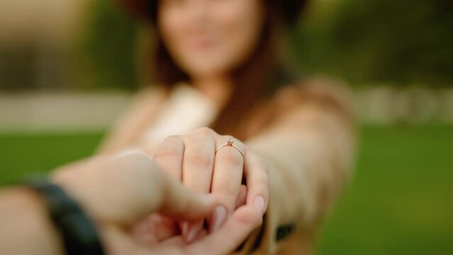 Man proposing to woman in autumn park. Marry me. Romantic photo of  charming woman. Male holding woman's hand with a wedding ring on her finger. 