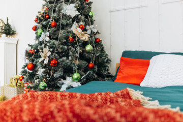 Cozy flat apartment photo studio room green Christmas Tree gifts presents garlands, candles decorated toys balls interior New Year lights glowing bokeh

