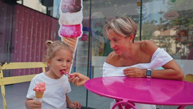 Happy mother and son eating ice cream. Close-up of a little boy and a young woman eating an ice cream together