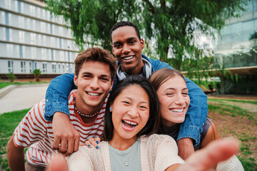 Group of young multiracial high school students taking a selfie portrait picture outside with a toothy smile looking at camera laughing and having fun together. Happy friendly teens shooting a photo