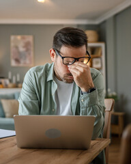 Man overworked freelancer at home hold eyes eyestrain pain