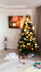 Blur bokeh defocused cozy flat apartment photo studio room green Christmas Tree TV set television teddy bear gifts presents garlands, candles decorated toys balls interior New Year lights glowing

