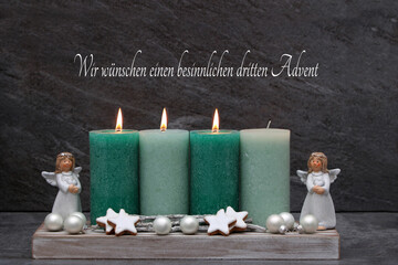 Dritter Advent:: Schlichte Adventsdekoration mit grünen Kerzen, Engel und Zimtsternen.	