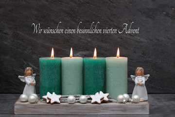 Vierter Advenr: Schlichte Adventsdekoration mit grünen Kerzen, Engel und Zimtsternen.	