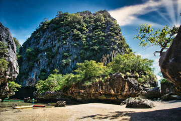 A group of boats sitting on top of a sandy beach. Photo of boats resting on a beautiful sandy beach in Thailand