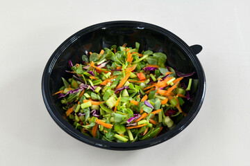 Green salad with arugula, lamb and tomatoes. Healthy vegan dish. Top view at table. Turkish Coban (choban) salata or Shepherds salad, Akdeniz salad in white bowl.