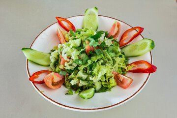 Green salad with arugula, lamb and tomatoes. Healthy vegan dish. Top view at table. Turkish Coban (choban) salata or Shepherds salad, Akdeniz salad in white bowl.