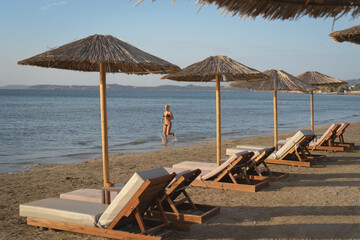 A beautiful girl in a swimsuit runs on the beach in Greece in the summer.
