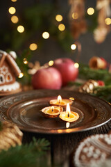 Candles made of bees wax and nut shells floating in water, with Christmas decoration