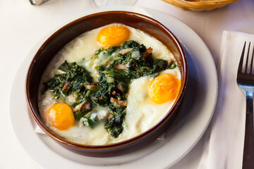 Image of fried eggs with spinach, raisins and ham, dish of Catalan cuisine