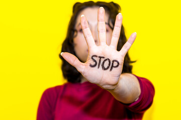 Close-up of a woman's hand with the word stop written on it. Concept of struggle and equality of women's rights. Women's day.