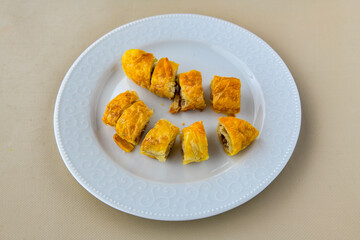 Turkish style meat stuffed filo dough borek served kol boregi. Cheese and minced pie are sliced on a marble background. Turkish name: Kol Boregi, ispanakli, kiymali, Su Boregi
