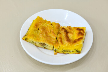 Turkish style meat stuffed filo dough borek served kol boregi. Cheese and minced pie are sliced on a marble background. Turkish name: Kol Boregi, ispanakli, kiymali, Su Boregi