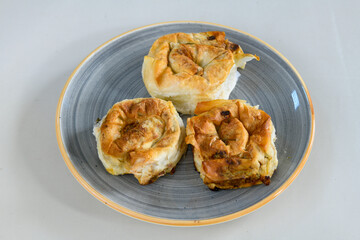 Turkish style meat stuffed filo dough borek served kol boregi. Cheese and minced pie are sliced on a marble background. Turkish name: Kol Boregi, ispanakli, kiymali, Su Boregi