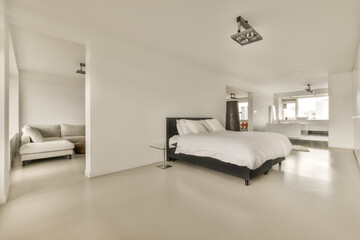 a modern bedroom with white walls and light gray flooring the room is well lit, but there is no one...
