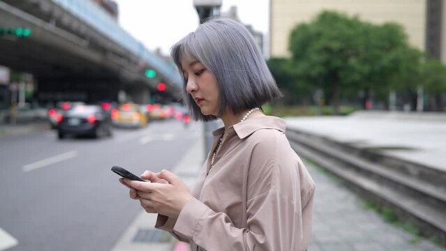 台北の都市部でタクシーを待つ若い台湾人女性  Young Taiwanese woman waiting for a cab in urban Taipei