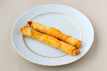 Turkish style meat stuffed filo dough borek served kol boregi. Cheese and minced pie are sliced on a marble background. Turkish name: Kol Boregi, ispanakli, kiymali, Su Boregi