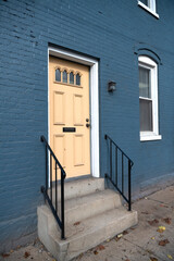 front door to a brick house. concrete steps at the entrance.