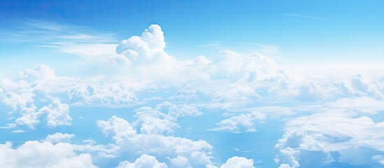 A view of the sky and clouds seen from an airplane window with a background of nature