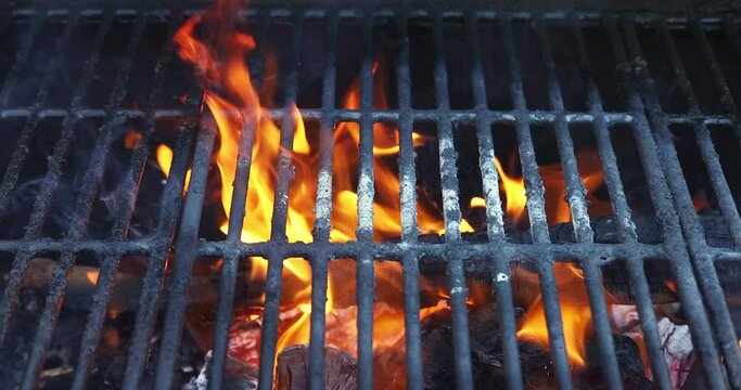 Using grill as fire pit for preparing coals for roasting barbecued meats fire is being lit