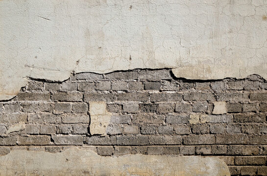 Fototapeta gray brick wall covered with gray cement with a break in the cement