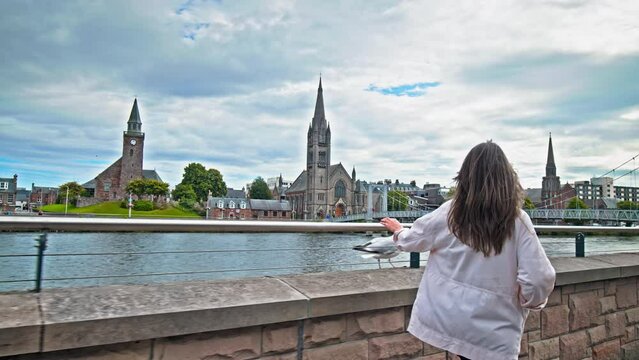 A tourist with a camera explores an old city in Scotland. A beautiful woman visiting the Old Town of Inverness, the largest city and the cultural capital of the Scottish Highlands.