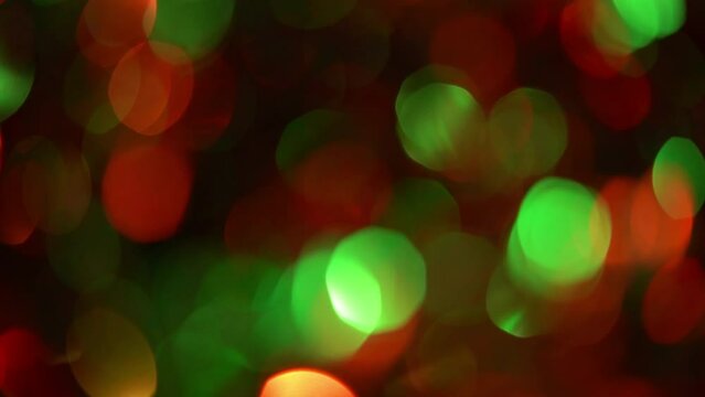 Christmas Bokeh Flicker And Fade Diagonally. Christmas abstract background or transition for footages. Red and green illuminated blurred circles on a black backdrop.