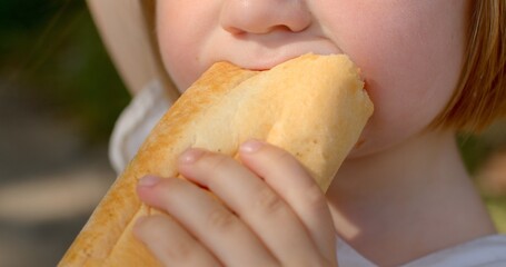 Healthy eating habits. Detailed view of a child's mouth as they consume food, focusing on the topic...
