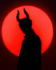 Fotobehang silhouette of a devil with horns on red circle background © Hamburn