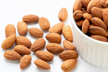 器からあふれたアーモンド(ビタミンEや食物繊維を多く含み美容や健康によいと言われるナッツ)。
