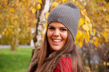 Portrait of a young attractive long haired brunette in the park