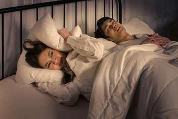 woman frustrated by partner's snoring during a restless night