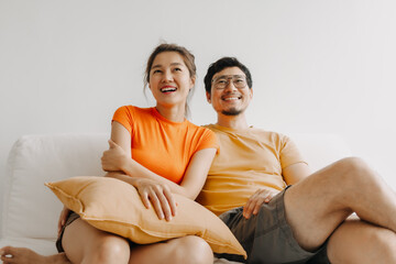 Fototapeta na wymiar Lovely romantic asian couple watching tv movie together happy vibes weekends.