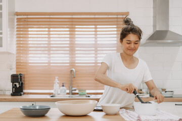 Asian woman bringing out the soup to be served.