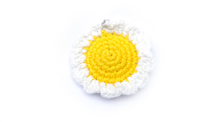 Amigurumi. Miniature flower keychain in white with yellow colors crocheted on a white background....