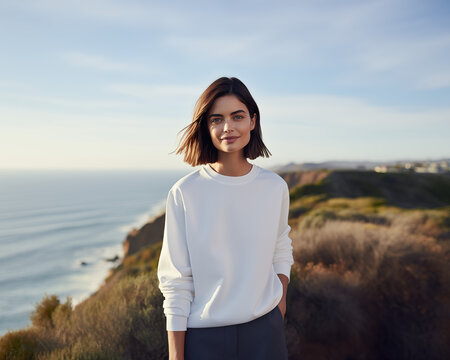 Sweatshirt mockup a portrait photograph of a beautiful woman female standing outside in nature on a hill above the ocean beach sea