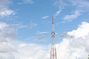 Cell phone signal towers and red and white internet on a background of blue sky and white clouds.
