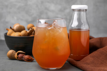 Freshly made tamarind juice on grey wooden table, closeup