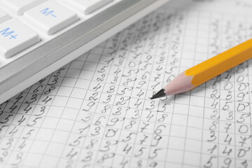 Calculator and pencil on document with data, closeup view