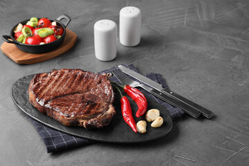 Delicious fried beef meat served on grey table