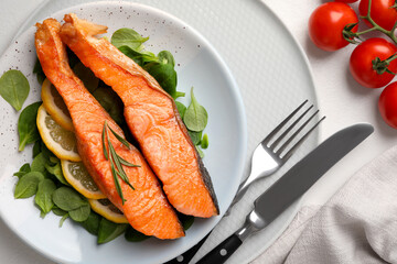 Healthy meal. Pieces of grilled salmon, spinach, lemon and rosemary served on white table, flat lay