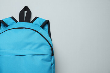 One blue backpack on light background, top view. Space for text - obrazy, fototapety, plakaty