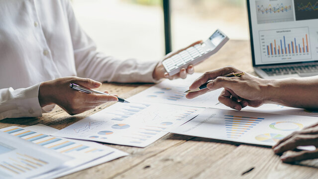 business team working They are analyzing financial reports and using calculators. accounting calculations And partners point to financial reports to analyze the company's sales plans.