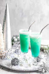 Two Jack Frost cocktails on a platter surrounded by festive decorations.