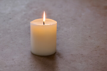 A burning candle emits a soft, warm glow as it consumes the wick, creating a soothing and atmospheric ambiance. 