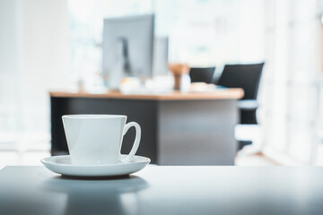 Coffee cup on office table with background of modern office. Coffee break relaxation time. Jivy