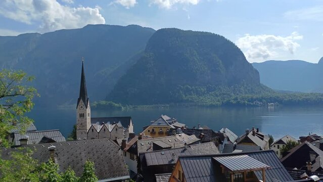 Mountain landscape in Austria Alps at summer morning with many roofs and Evangelical Church tower in Hallstatt old town, Austria.