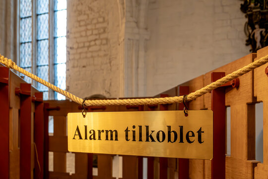 Odense, Denmark A sign in Danish inside the St. Canute's Cathedral, Sankt Knuds Kirke, at the altar says the Security Alarm is connected.